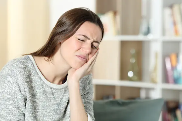 woman in pain holding jaw